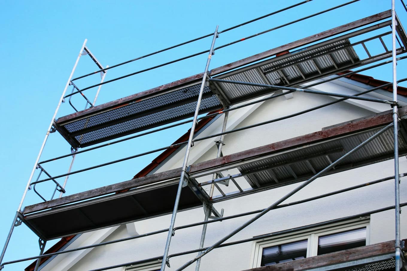 rusztowanie przy domu z białą elewacją